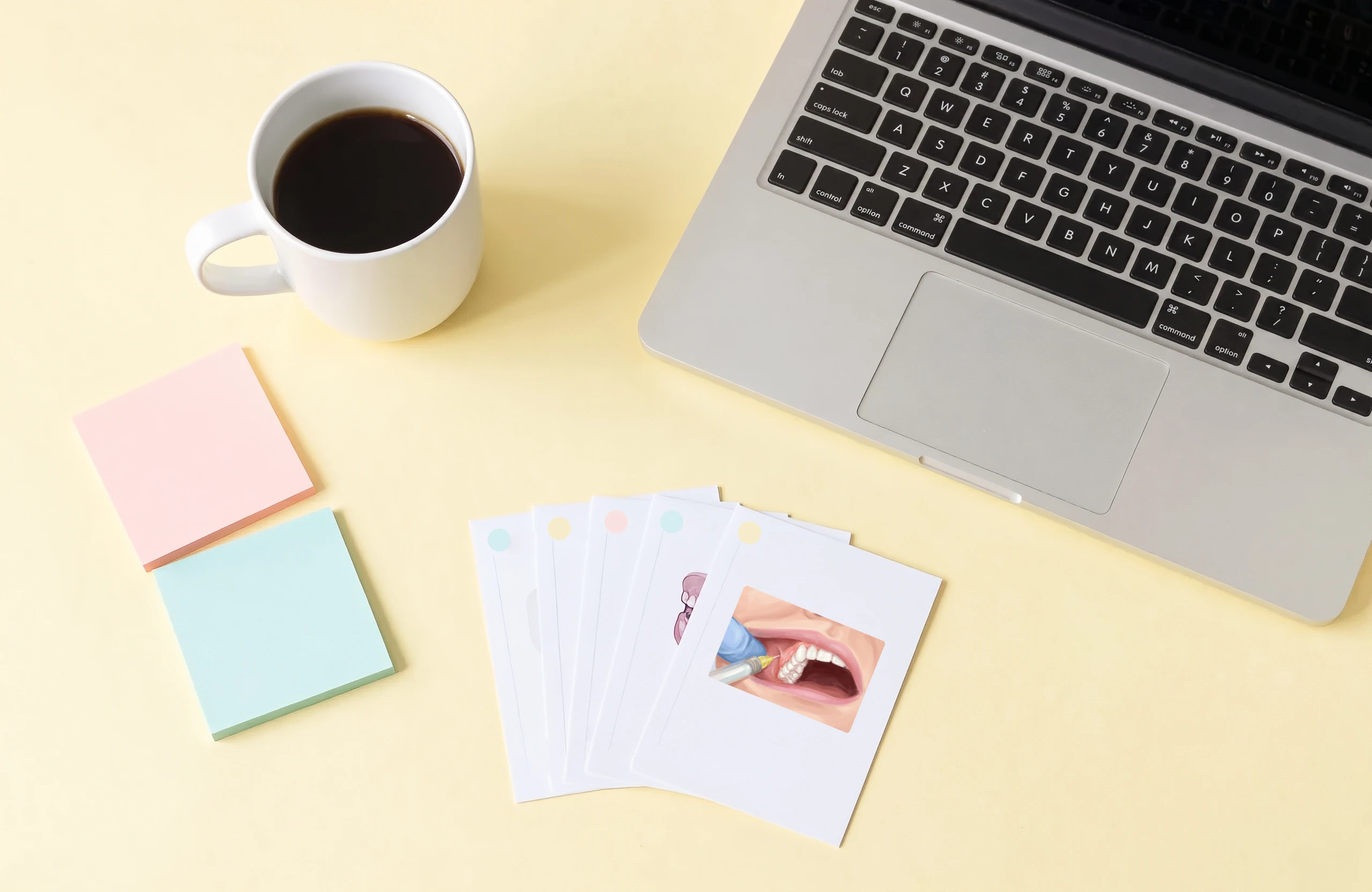 Study flashcards and a coffee beside a laptop